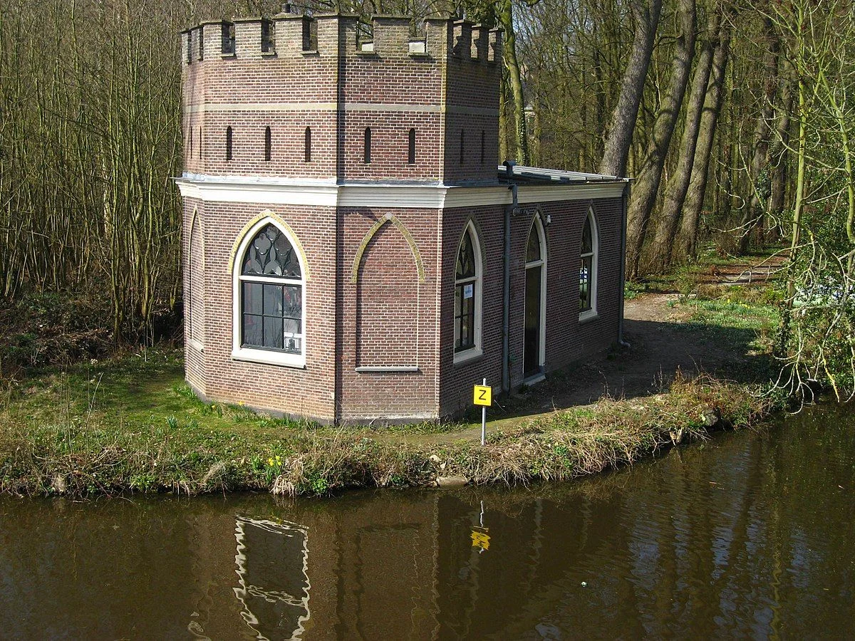 Het jagershuis met kantelen aan het water op het landgoed