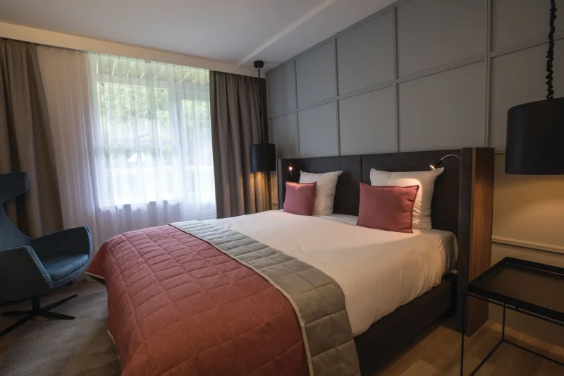 Estate room with a double bed and an armchair by the window