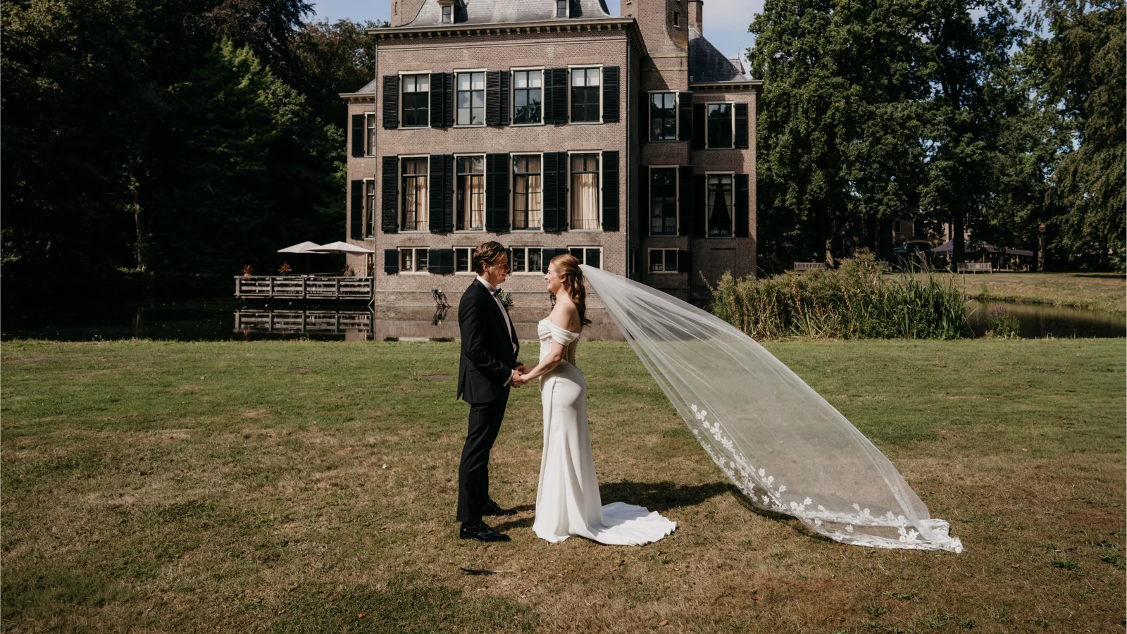 Bruidspaar voor het kasteel bij een ceremonie in de tuin