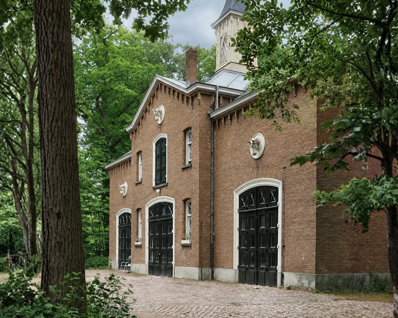 Landgoedkamer met tweepersoonsbed en fauteuil bij het raam