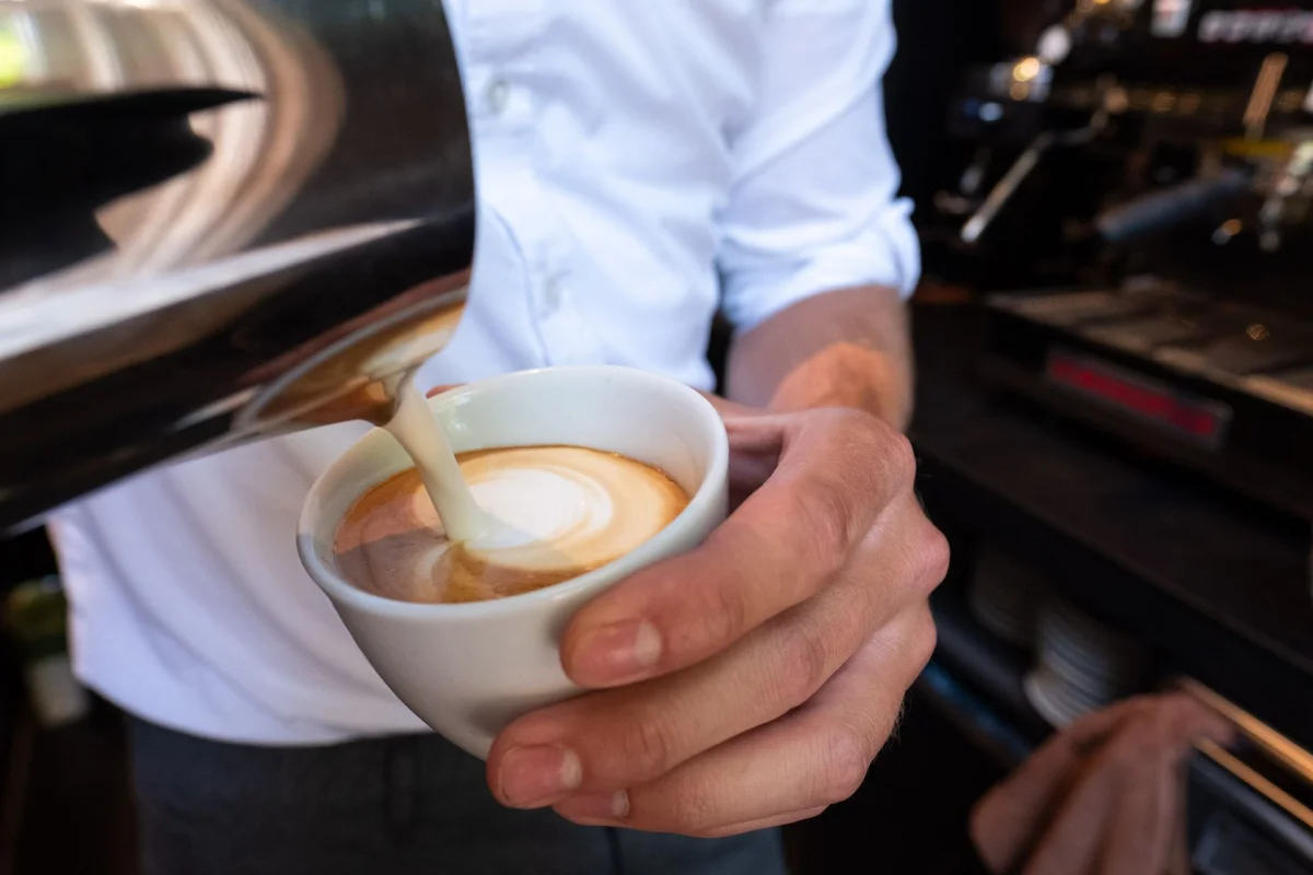 Barista schenkt een cappuccino aan de bar
