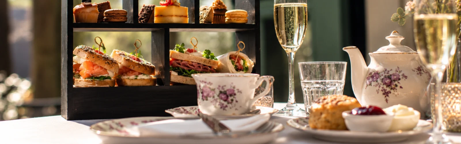 High tea met etagères op tafel in de salon met marmeren schouw