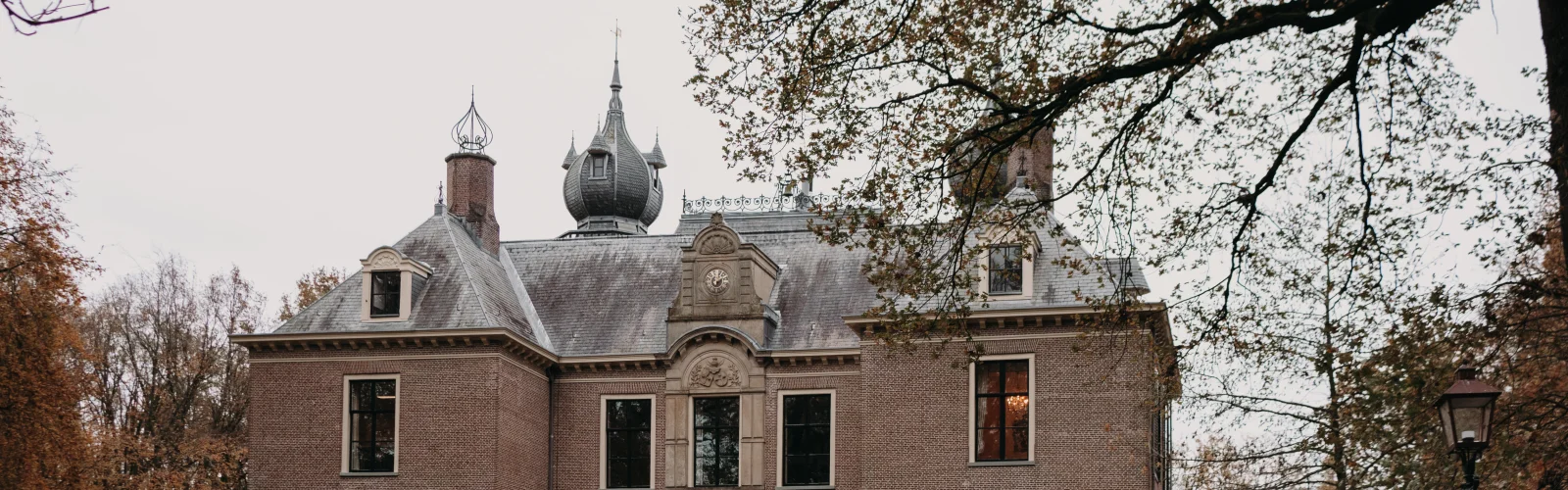Bovenhal met ballondecoratie, kroonluchter en statafels