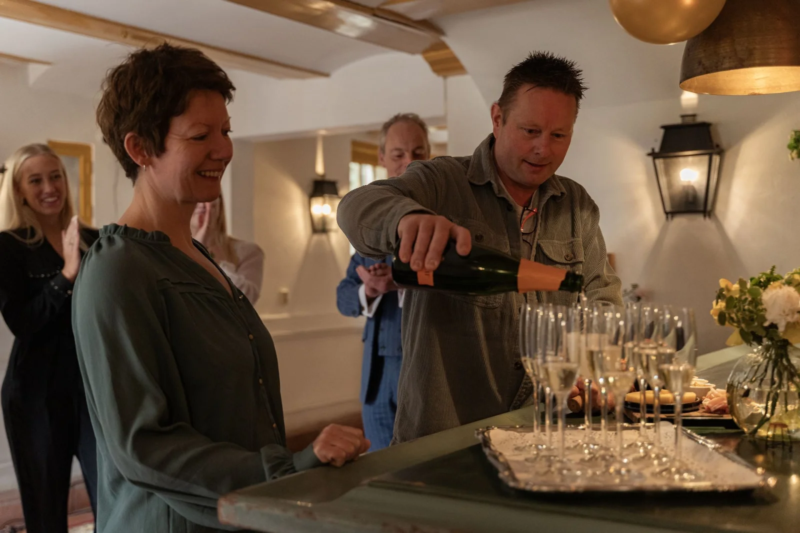 Host pouring champagne for a party of guests